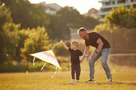 Active weekend, running with kite in hand. Happy father with son on the field