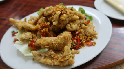close up of Cantonese dish deep fried Bombay Duck fish with Spicy Salt on a white plate