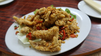 close up of Cantonese dish deep fried Bombay Duck fish with Spicy Salt on a white plate