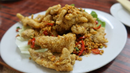 close up of Cantonese dish deep fried Bombay Duck fish with Spicy Salt on a white plate