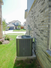 Tidy suburban HVAC setup with outdoor AC unit on concrete pad, brick home exterior, trimmed lawn, new residential street background in Princeton Texas. Home maintenance or infrastructure themes