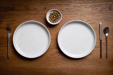 Setting a table for dinner with empty plates, silverware, and a bowl of snacks on a wooden surface