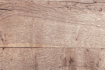 Close-up of a textured wooden surface with natural grain patterns. The wood is light brown with...