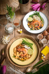 Pad Thai Pad Thai with rice vermicelli and shrimp with ingredients placed on the table.
