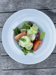 Colorful and healthy mixed salad featuring fresh lettuce, sliced tomatoes, and cucumbers