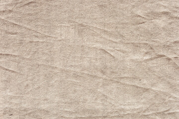 Textured beige fabric with visible wrinkles and folds. The surface soft and natural, suitable for various design applications.