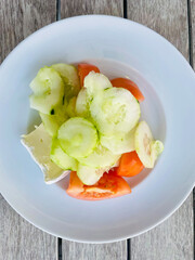 Colorful and healthy mixed salad featuring fresh lettuce, sliced tomatoes, and cucumbers