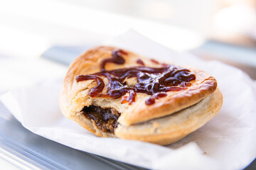 pie covered in sauce sitting on a paper bag