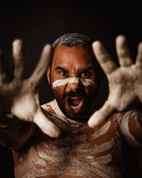 Aboriginal holding hands up yelling headshot