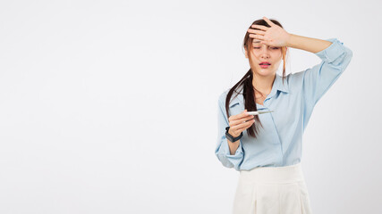 Woman is sick with a high temperature, feels unwell, she asian, has flu symptoms checking forehead...