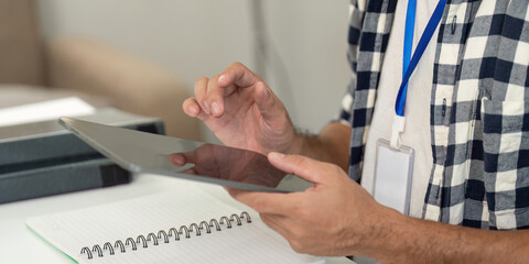 Remote Work. Professional man using tablet for digital tasks in a modern office.