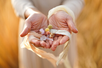 Woman is holding a bunch of flowers and a piece of string