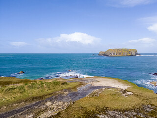 Fototapeta premium Aerial view on Cliffs and coast of Atlantic Ocean, Carrick a Rede Rope Bridge in Ballintoy, Northern Ireland. 