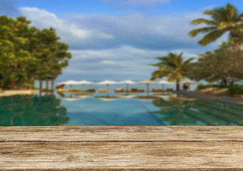 Fototapeta premium Wooden table top on the beach or sea. swimming pool Party on the beach sunshine time concept.For montage product display or design key visual layout.View of copy space.