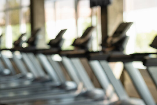 Blurred gym background, sports fitness center with treadmills and exercise equipment in defocus. Abstract sport background. Space for design.