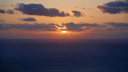 Obraz premium Serene sunset over the ocean with dramatic clouds