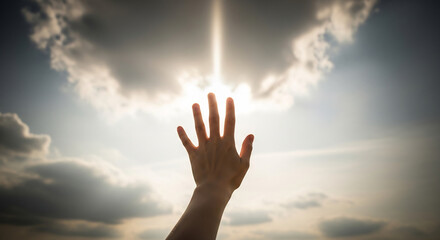 Hand reaching toward bright light in cloudy sky, symbolizing hope, peace, and solemn remembrance. Seeking a future light after darkness.