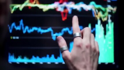 Hand interacting with stock market data on a screen showing financial analysis - Powered by Adobe