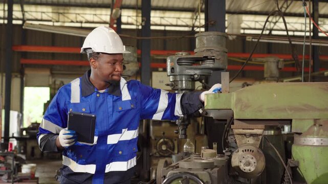 Worker or engineer checking machine and working on tablet in the factory