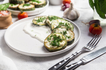 Appetizing Fried zucchini with garlic sauce in a white plate