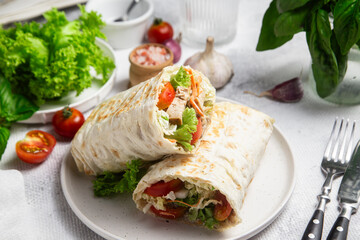 Appetizing Shawarma with chicken and fresh vegetables on a light background