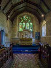 Historic church interior featuring vaulted wooden ceiling and colorful stained glass (The Parish Church of Saint Mary, Lower Slaughter, Gloucestershire, England, United Kingdom)