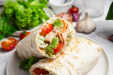 Appetizing Shawarma with chicken and fresh vegetables on a light background