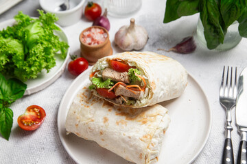 Appetizing Shawarma with chicken and fresh vegetables on a light background