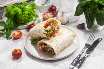 Appetizing Shawarma with chicken and fresh vegetables on a light background