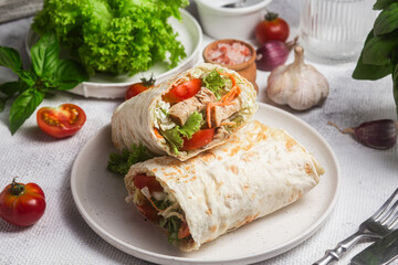 Appetizing Shawarma with chicken and fresh vegetables on a light background