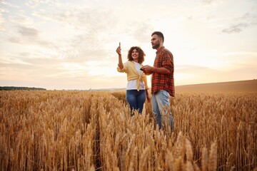 Taking a look at wheat piece. Two workers are on the agricultural field together © standret