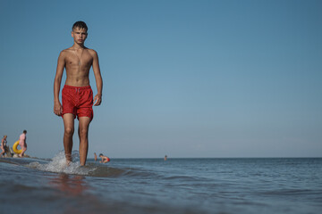 Summer Energy: Teen Boy Playing on the Beach. Teen Boy’s Summer Vacation by the Sea

