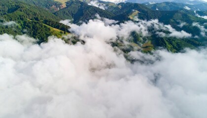Obraz premium Green Mountain Peaks Covered in Thick White Fog from an Aerial Perspective