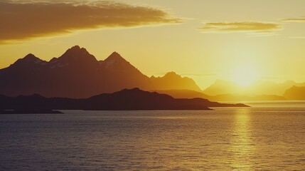 Golden sunset over a mountain range and tranquil water.