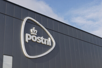 The prominent PostNL logo, featuring a crown and the company name, is mounted on the dark grey,...