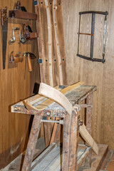 Historical ski workshop with traditional tools and wooden ski parts.