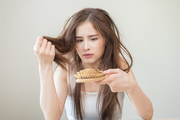 Damaged hair, amazed asian young woman, girl hand holding brush comb, hairbrush with fall hair from...