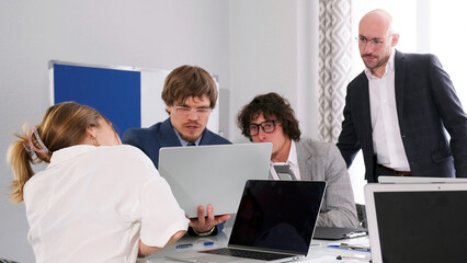 The company's managers and lawyers discuss the new project at a meeting. A group of people are...