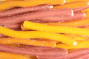 detail of lot red and yeollow licorice sticks on white background