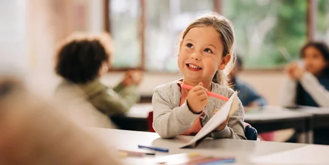 Young girl drawing in classroom during back to school season © Jacob Lund