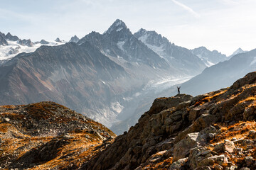 Monte Bianco mountains rise beyond hiker in foreground at Vallon de Berard Nature Preserve. Scenic French Alps view captured in peaceful outdoor adventure momen