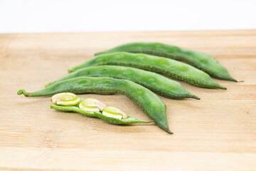 Close up of a wooden crate filled with broad beans, the green bean on background, closeup of broad bean Raw