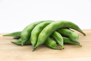 Close up of a wooden crate filled with broad beans,the green bean pods background. fresh vegetable,