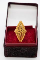 gold wedding ring with a box on a light background