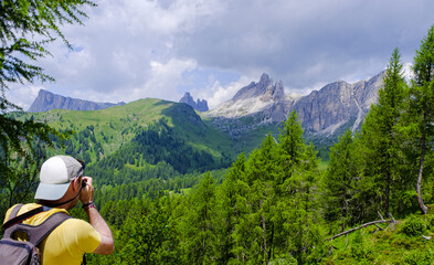 Hiker photographing the Dolomite Mountains, Italy