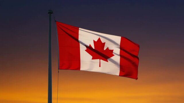 Canadian flag waving in the wind at dusk against darkening sky  