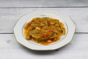 Homemade stewed green beans, tomatoes, garlic with olive oil. Zeytinyagli fasulye traditional food. Turkish cuisine.