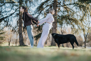 A pair of women engage in an outdoor fitness routine, showcasing togetherness while accompanied by...