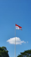 Indonesian flag waving proudly in a clear blue sky.