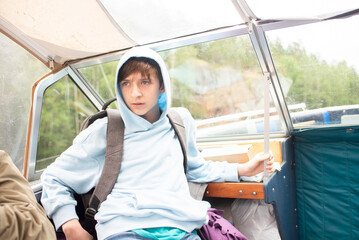 A 12 year old boy sits on a boat on a water excursion.	